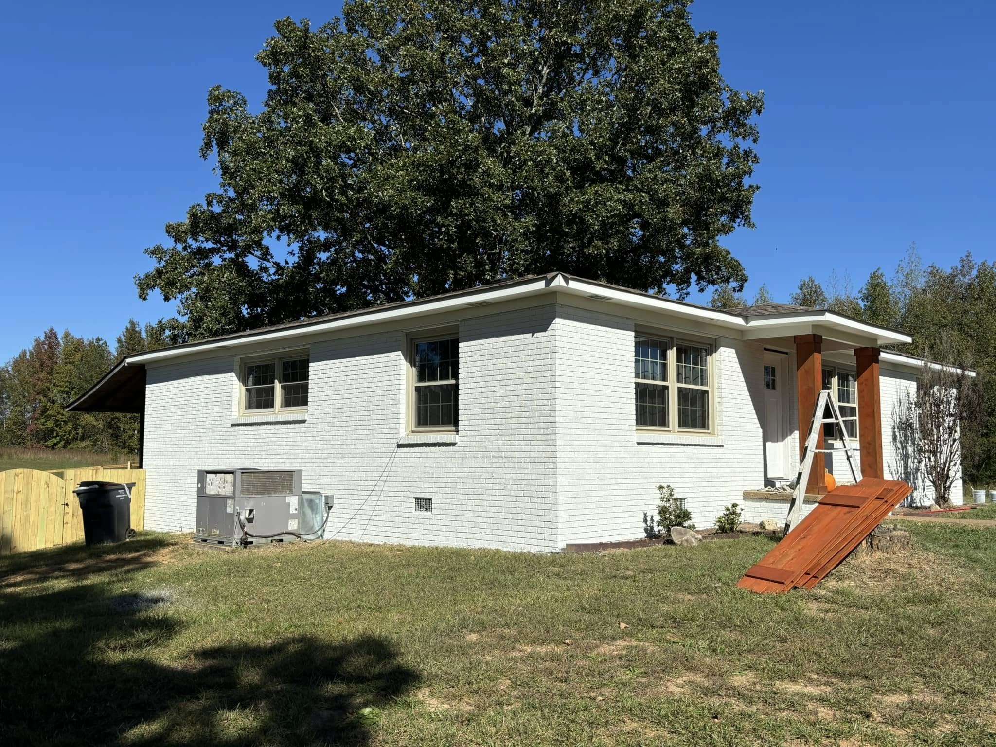 House with white siding walls, view from the yard, surrounded by a green lawn