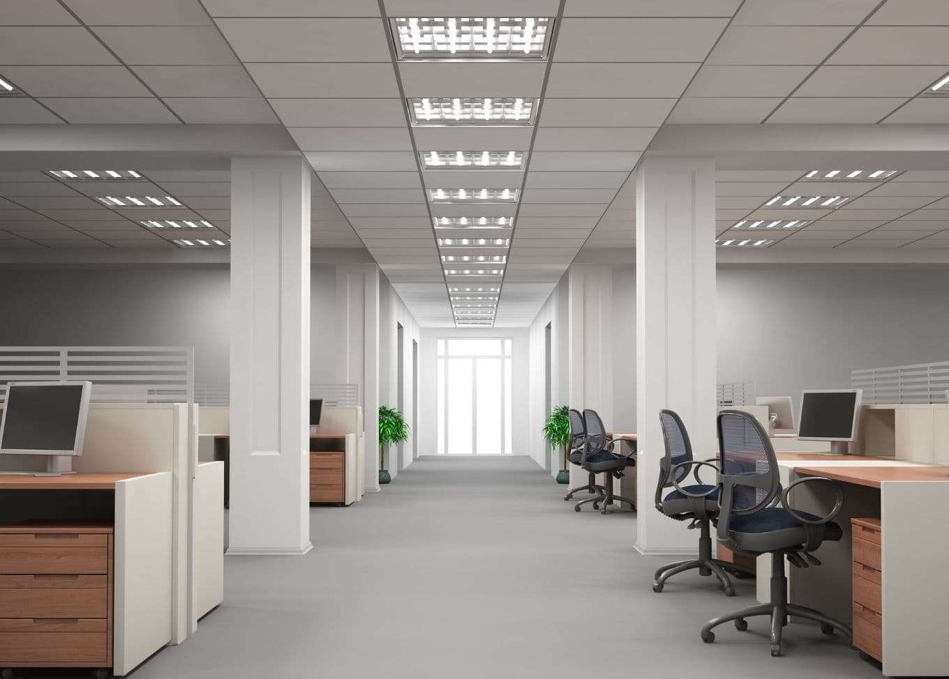 Office interior with freshly painted walls, wide walkway, office chairs, and computer tables with cabinets